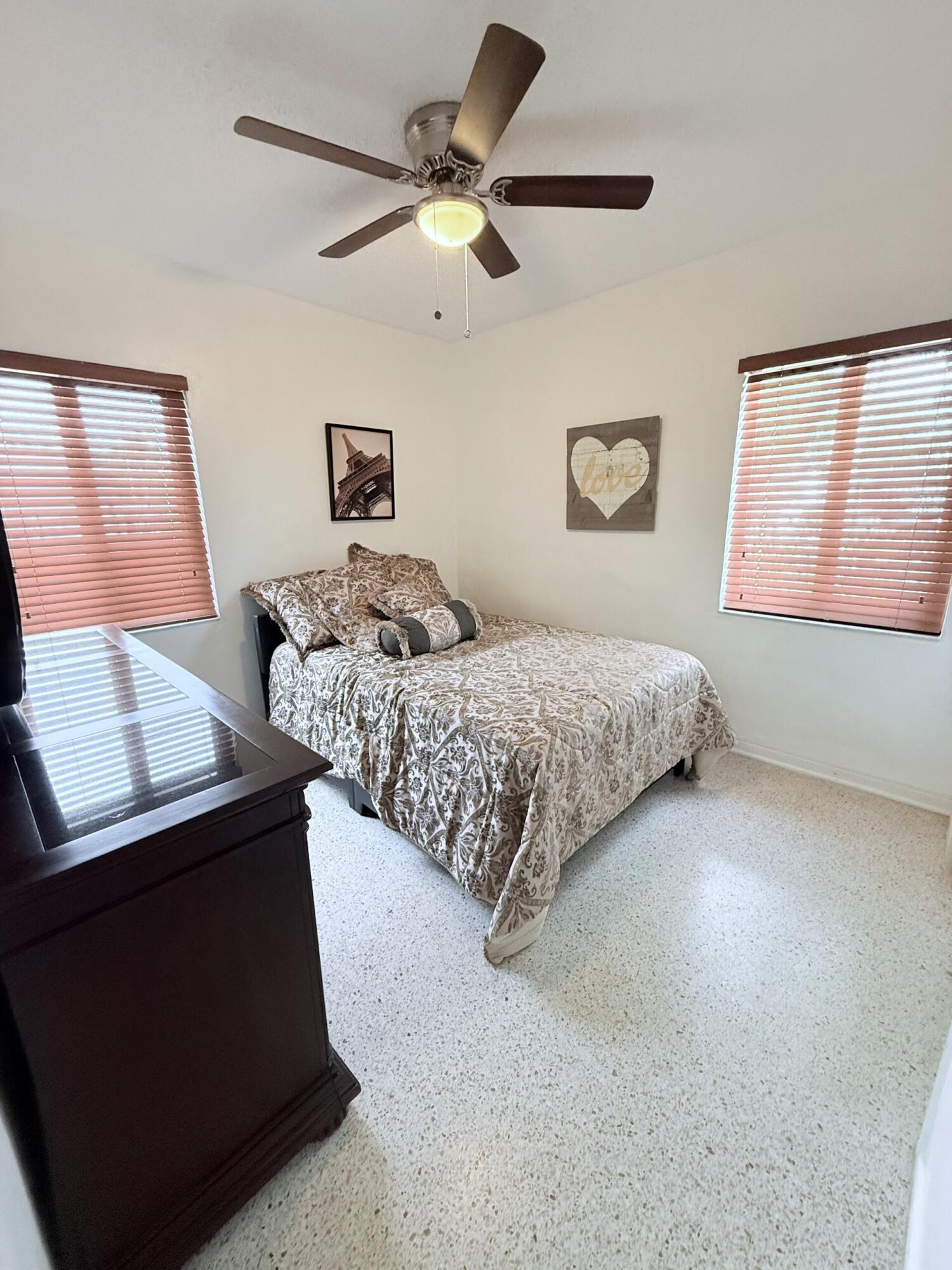 957 West 67th Street Hialeah, FL 33012 - Photo 11 of 15 a bedroom with a bed and a ceiling fan