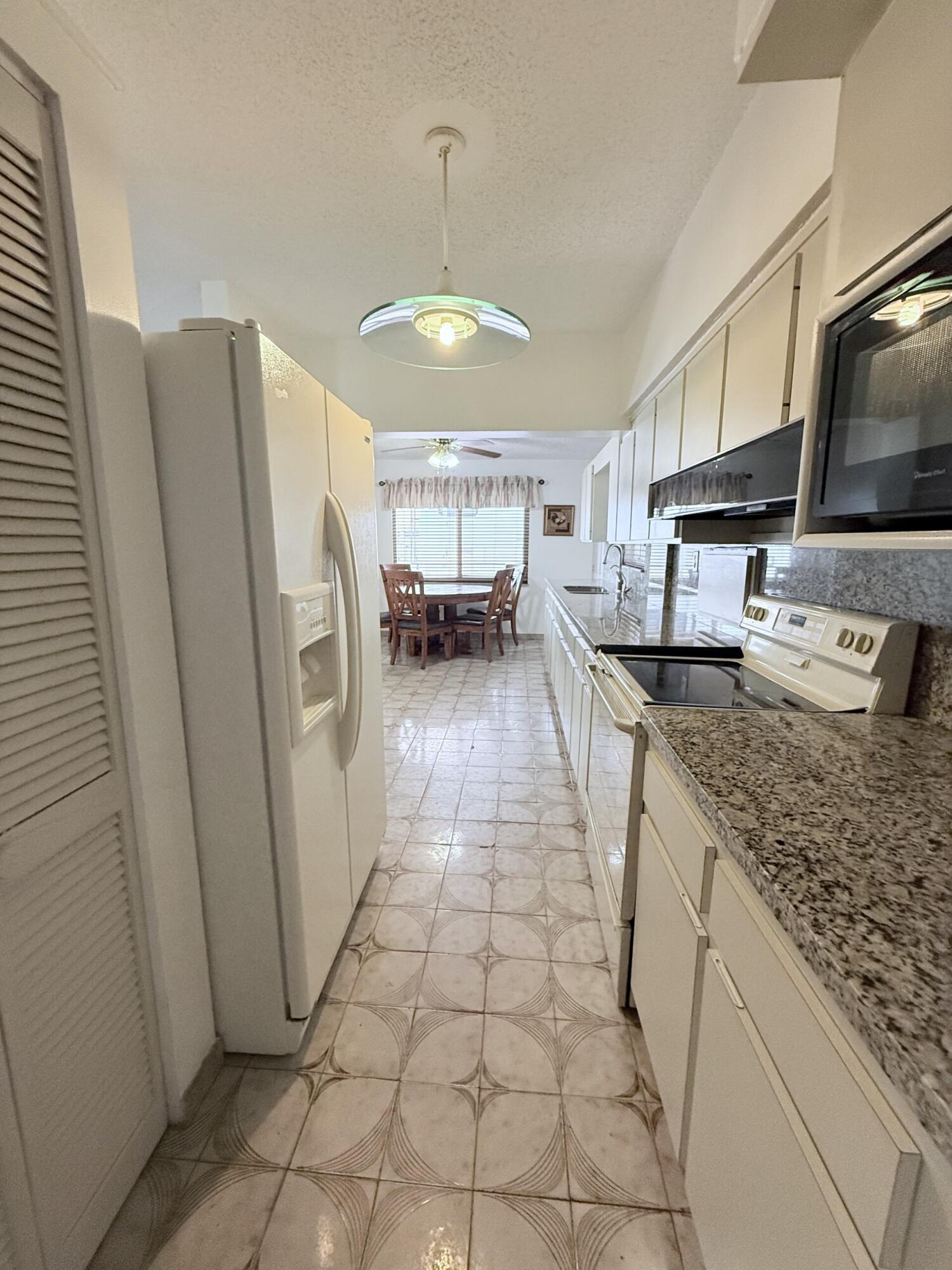 957 West 67th Street Hialeah, FL 33012 - Photo 7 of 15 a kitchen with stainless steel appliances granite countertop a refrigerator a sink and a stove