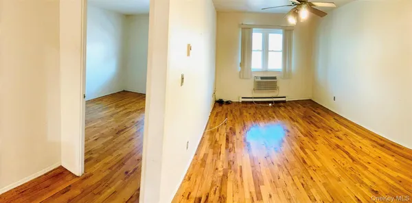 a view of a room with wooden floor and a window