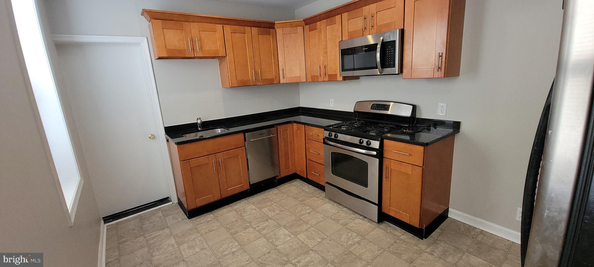 2643 Emerald Street Philadelphia, PA 19125 - Photo 4 of 14 a kitchen with stainless steel appliances granite countertop a stove a sink and a microwave
