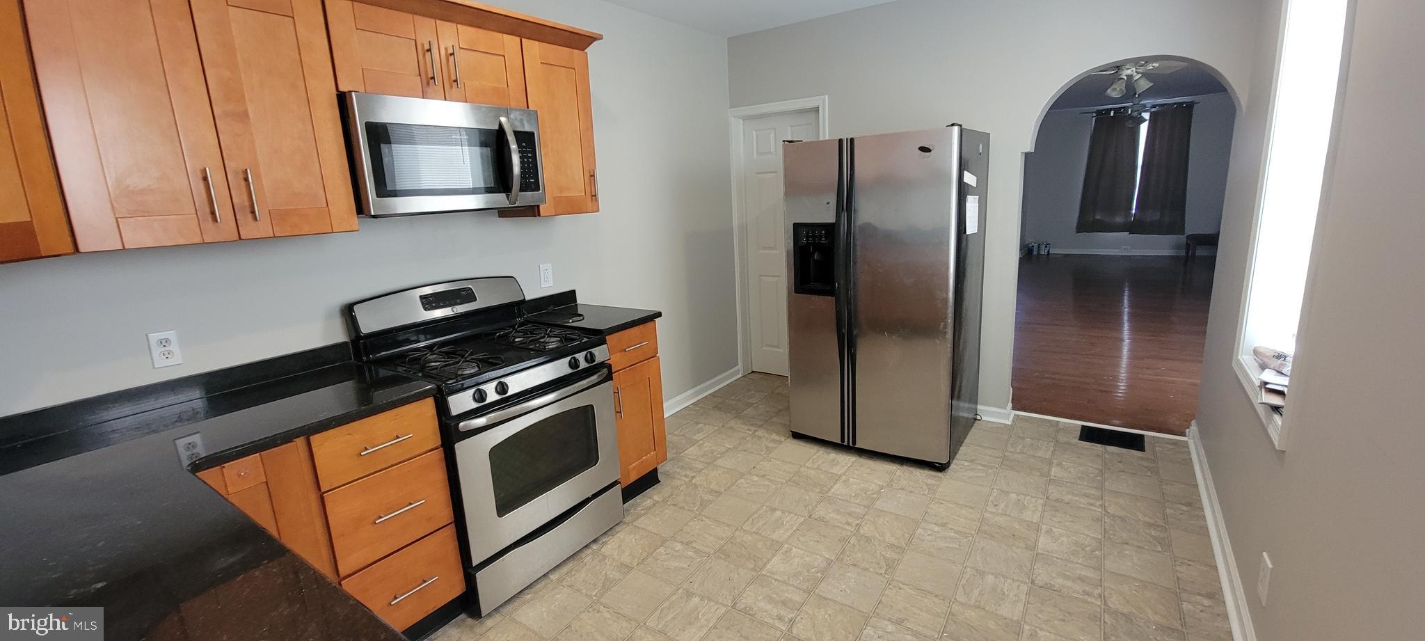 2643 Emerald Street Philadelphia, PA 19125 - Photo 5 of 14 a kitchen with stainless steel appliances granite countertop a refrigerator a stove and a sink with wooden floor