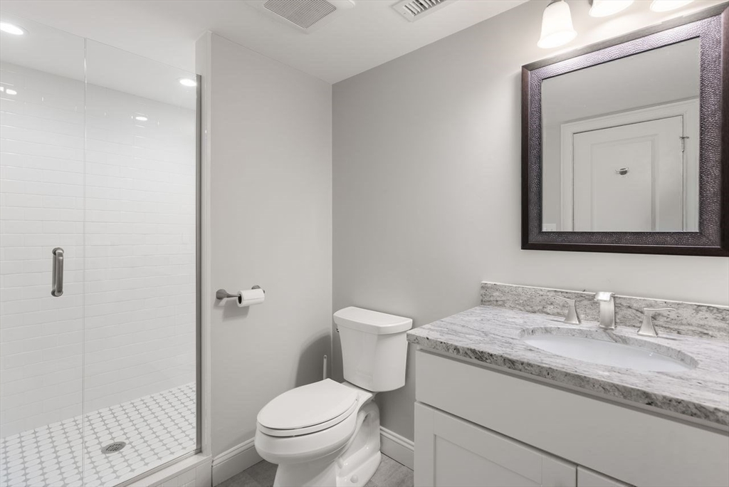 72 Great Plain Avenue Wellesley, MA 02482 - Photo 34 of 38 a bathroom with a granite countertop toilet a sink and a mirror