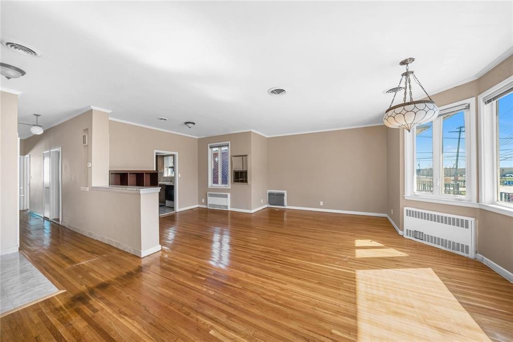 187 Irwin Street Brooklyn, NY 11235 - Photo 8 of 12 a view of kitchen and empty room with wooden floor