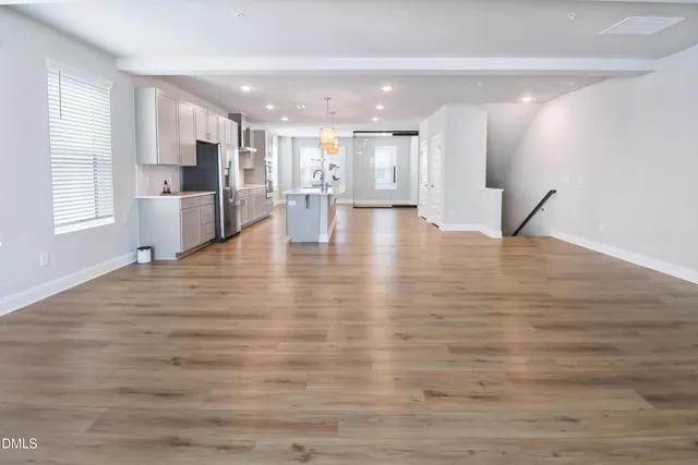a view of an empty room with kitchen appliances and window