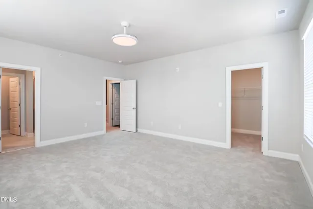 an empty room with windows and closet