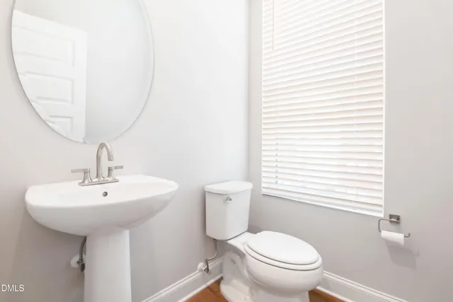 a bathroom with a toilet a sink and a mirror