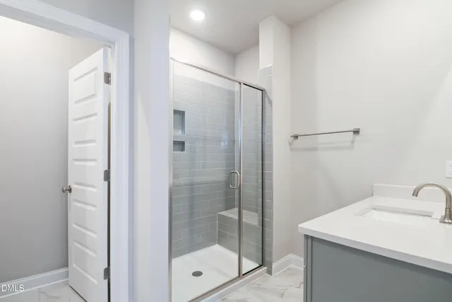 a bathroom with a shower sink and mirror