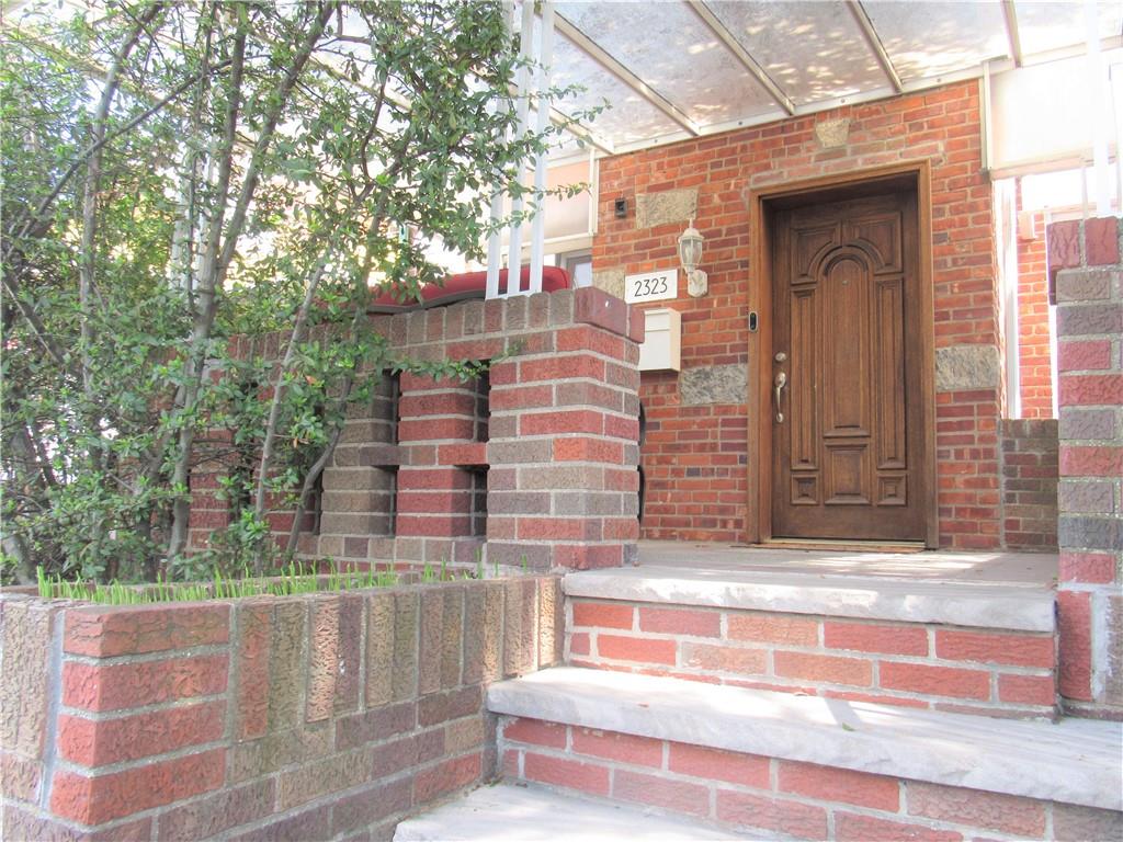 a view of a brick building with a bench in front of house