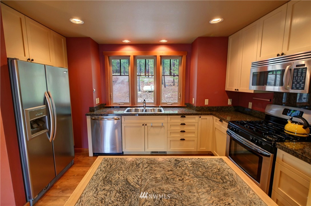 23 Bitterbrush Road Winthrop, WA 98862 - Photo 14 of 36 a kitchen with stainless steel appliances granite countertop a refrigerator a stove and a sink
