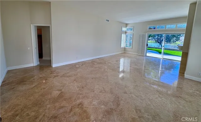 a view of an empty room with wooden floor and a fireplace