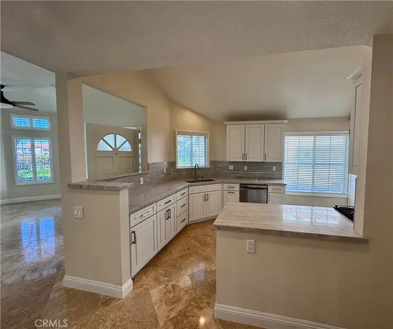 a kitchen with granite countertop white cabinets and white appliances