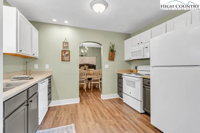 a kitchen with stainless steel appliances a stove a sink cabinets and a wooden floor