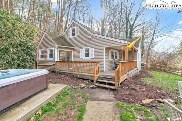 a view of a house with a yard and wooden fence