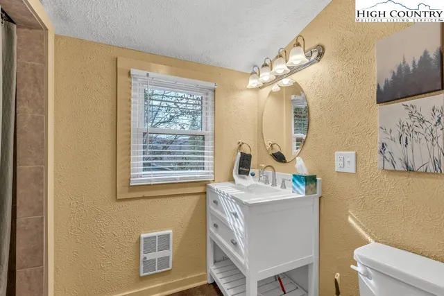 a bathroom with a sink a toilet and a mirror