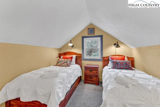 a bedroom with a bed and painting on the wall