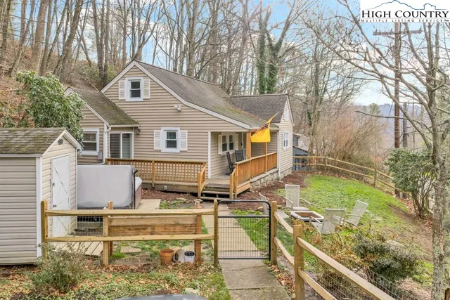 a view of a white house with a yard and furniture