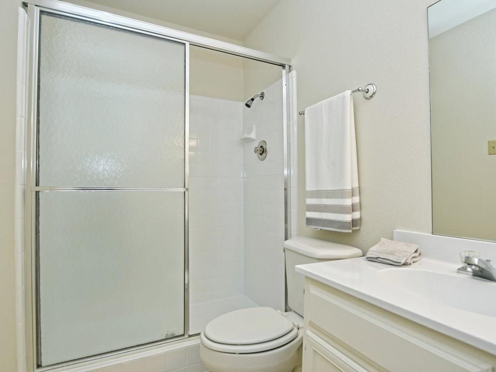 4159 Steck Avenue, Unit 278 Austin, TX 78759 - Photo 18 of 30 Bathroom with vanity, a shower stall, and a textured wall
