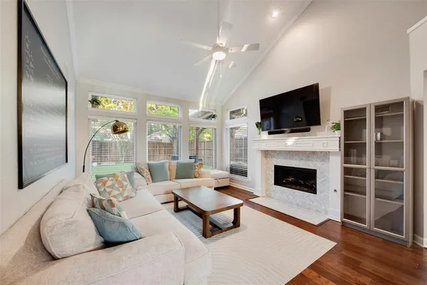 a living room with furniture a flat screen tv and a fireplace