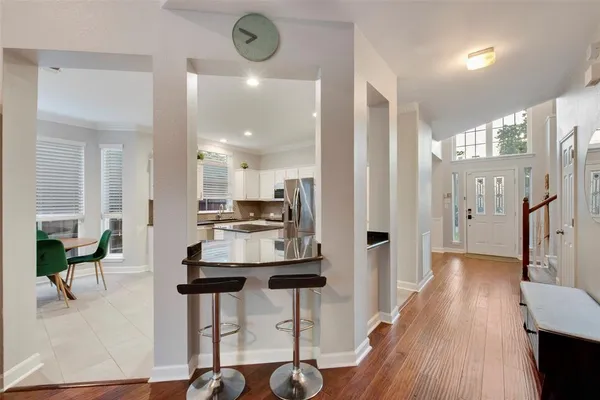 a kitchen with stainless steel appliances kitchen island granite countertop a dining table chairs and granite counter tops