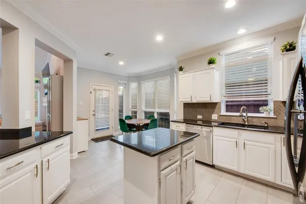 a kitchen with granite countertop a sink stove and cabinets