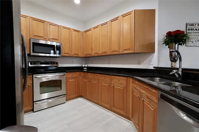 a kitchen with granite countertop a sink stainless steel appliances and cabinets