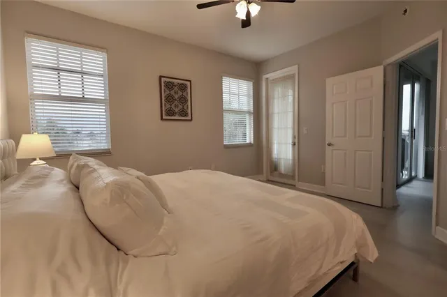 a bed sitting in a spacious bedroom next to a window and a chandelier