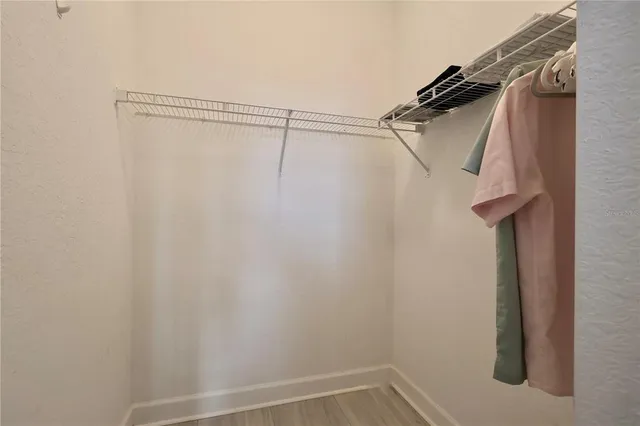 a view of walk in closet with clothes