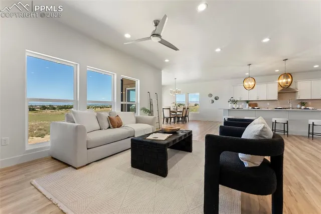 a living room with furniture kitchen area and a window