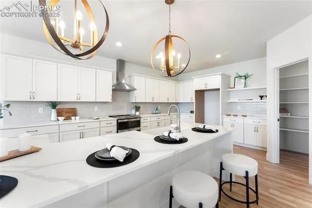 a kitchen with stainless steel appliances a table chairs and a stove