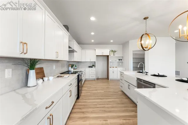 a large kitchen with stainless steel appliances granite countertop a lot of counter space and a sink