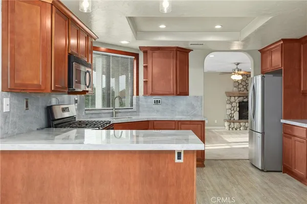 a kitchen with stainless steel appliances granite countertop wooden cabinets a granite counter tops and a large window