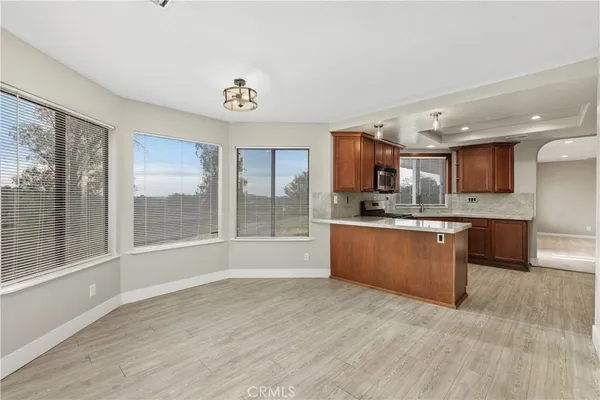 a large kitchen with stainless steel appliances granite countertop a large counter top and a wooden floors