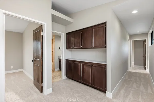 a view of a kitchen with stainless steel appliances granite countertop wooden cabinets and entryway