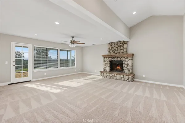 a view of an empty room with a fireplace and a window
