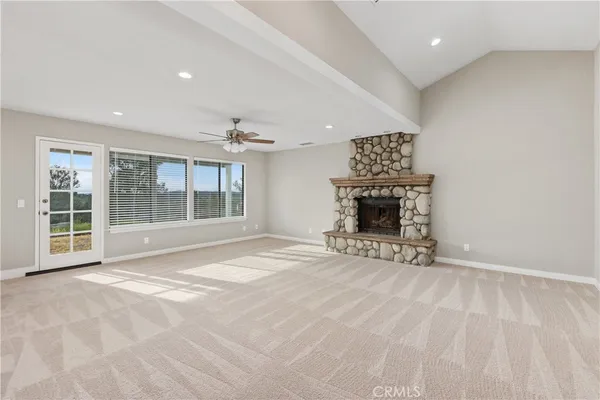 a view of an empty room with a fireplace and a window
