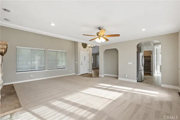 a view of a livingroom with a chandelier fan and windows