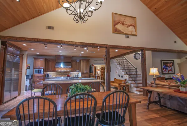 a kitchen with stainless steel appliances granite countertop a table chairs and a refrigerator