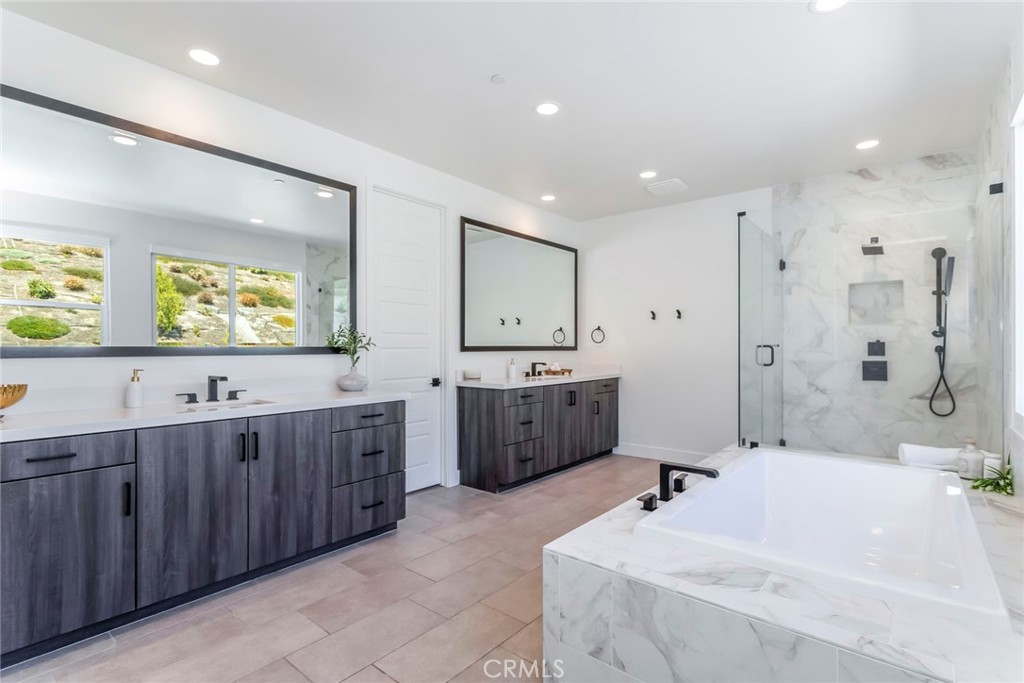 17701 Ridgeline Court Saugus, CA 91350 - Photo 28 of 61 a large bathroom with a double vanity sink large mirror and a bathtub