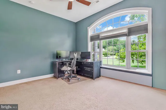 a view of a workspace with furniture and a window