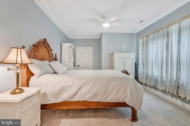 a bedroom with a large bed and chandelier fan