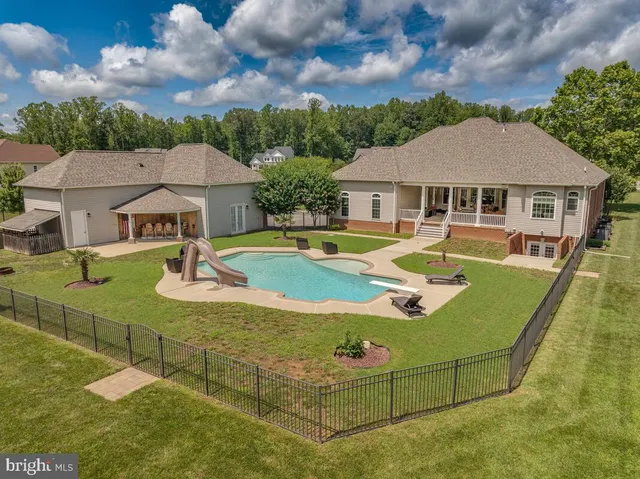 an aerial view of a swimming pool with yard