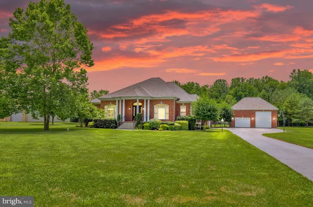 a front view of a house with a yard and trees