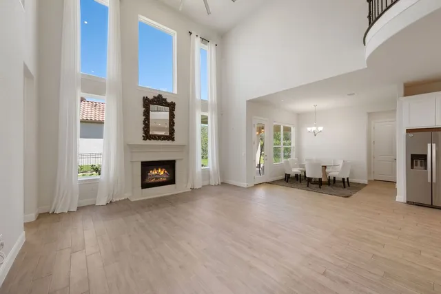 a view of an empty room with fire place and a window
