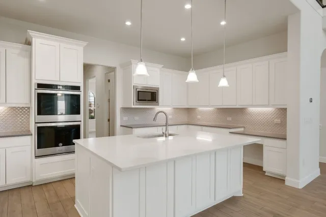 a kitchen with kitchen island a sink stainless steel appliances and cabinets