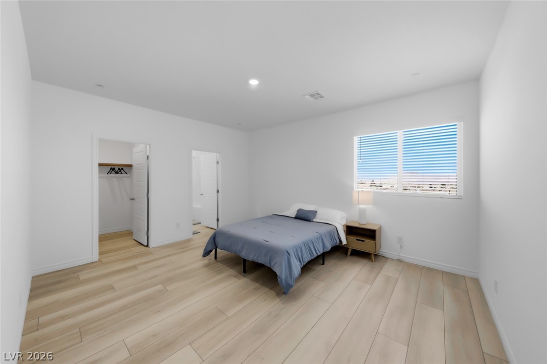 290 Rusty Ridge Lane Henderson, NV 89015 - Photo 19 of 61 Bed 2 is ensuite w/walk in closet & private bath, luxury vinyl plank floors, recessed lights