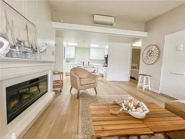 a living room with furniture a fireplace and kitchen view