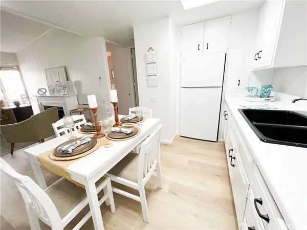 a kitchen with stainless steel appliances kitchen island granite countertop a table chairs and a refrigerator