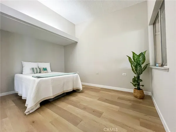 a bed sitting in a bedroom next to a window