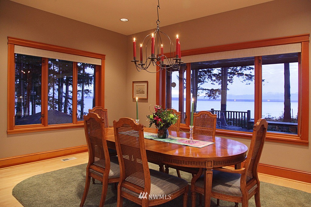 6966 Sills Road Clinton, WA 98236 - Photo 13 of 25 a dining room with furniture large windows and a chandelier