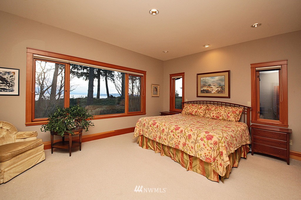 6966 Sills Road Clinton, WA 98236 - Photo 17 of 25 a bedroom with a large bed and a large window